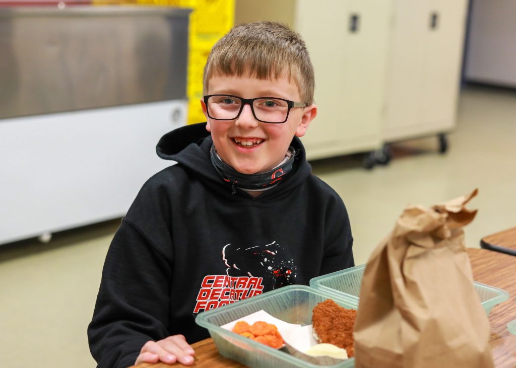 Elementary student with school lunch